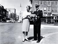 Male and female cabin crew of TEAL standing at the corner of Colombo and Armagh Streets [ca. 1960]