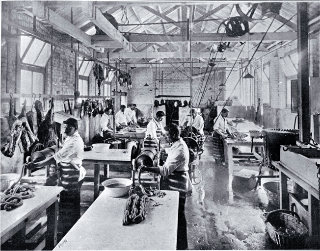 A small goods factory in Cashel Street, Christchurch : employees of the Christchurch Meat Co. Ltd. dicing meat and making sausages.