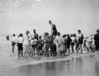 Surf life savers and crowd on New Brighton beach.