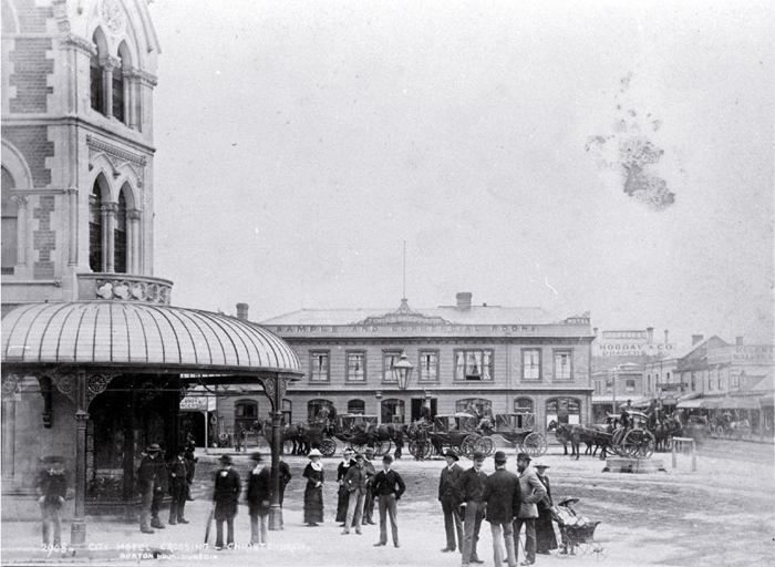 Hackney and hansom cabs at City Hotel crossing at the intersection of Colombo and High Streets : with Fishers' building at left.