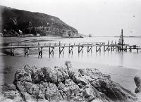 Construction of the Sumner Pier, Christchurch looking from Cave Rock past the Sumner Hotel to Clifton Spur and Shag Rock