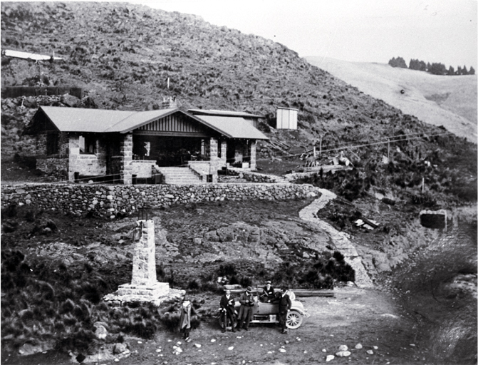 A car and excursionists in front of the Sign of the Kiwi, Dyers Pass, Summit Road, Christchurch 