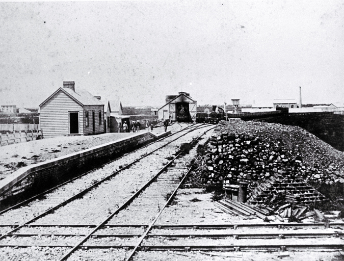 The first Christchurch railway station on the broad-gauge line that ran to Ferrymead : trains are no. 1 (Pilgrim) & no. 2 locomotives.