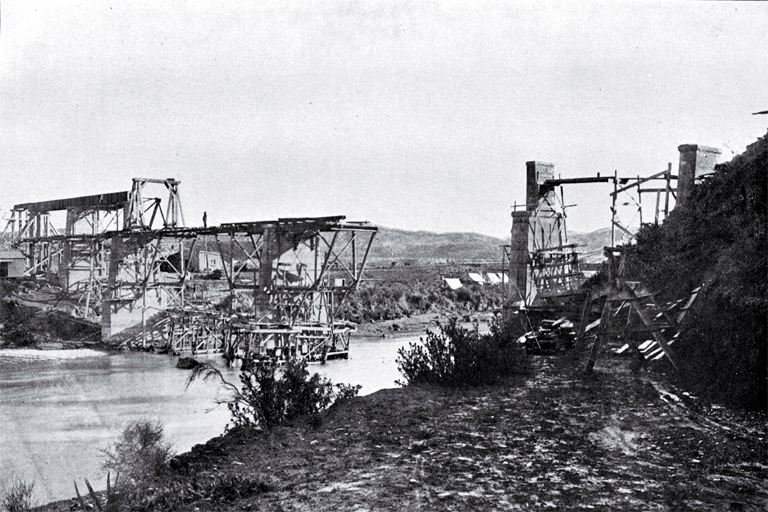 Construction of the Waipara-Cheviot railway bridge over the Hurunui River, using steel spans on timber and concrete piers 