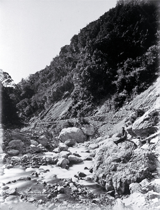 A roadman (?) sitting in the river bed beside the road through the Otira Gorge 