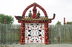 Carved lintel and stockade at the gateway entrance to Nga Hau e Wha National Marae.