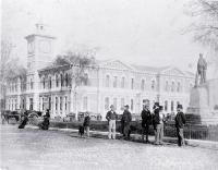 Cathedral Square, showing the Post Office and Godley statue, with delivery carts and pedestrians 