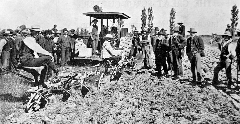 Breaking up old lea land with a two furrow and three furrow mould board plough.