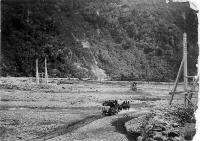Coaches shown passing under a swing bridge, crossing possibly the Otira River between Otira and Aickens.