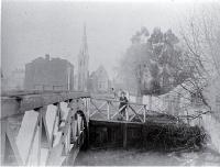 A man stands beside the Worcester Street Bridge : in background is the Cathedral, at left the Providential Society building.