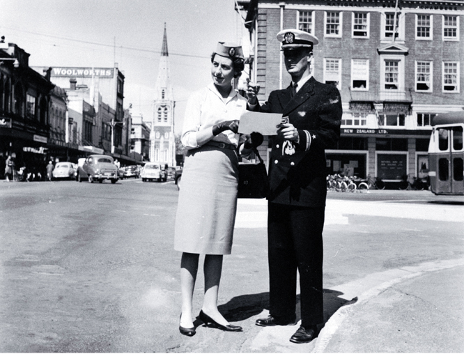 Male and female cabin crew of TEAL standing at the corner of Colombo and Armagh Streets 