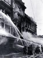 Firemen dampening down the main entrance of Ballantyne's, Colombo Street, Christchurch 