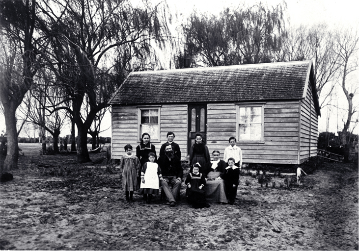 The family of Arthur John Inwood (1850-1932) and his wife Angelina (1860?-1919) pictured outside their dwelling 