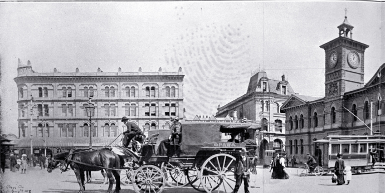The Opawa coach waiting to depart in Cathedral Square : in background is Mortens Building (United Service Hotel)