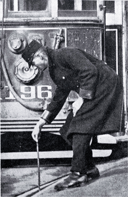 A tram conductor changes the points of the tram rails with a point bar 