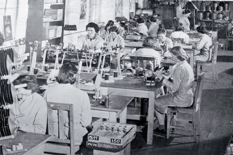 Girls in a small workroom engaged on assembly work 